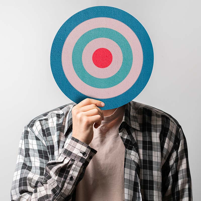 An image of a person holding up a target in front of theme.