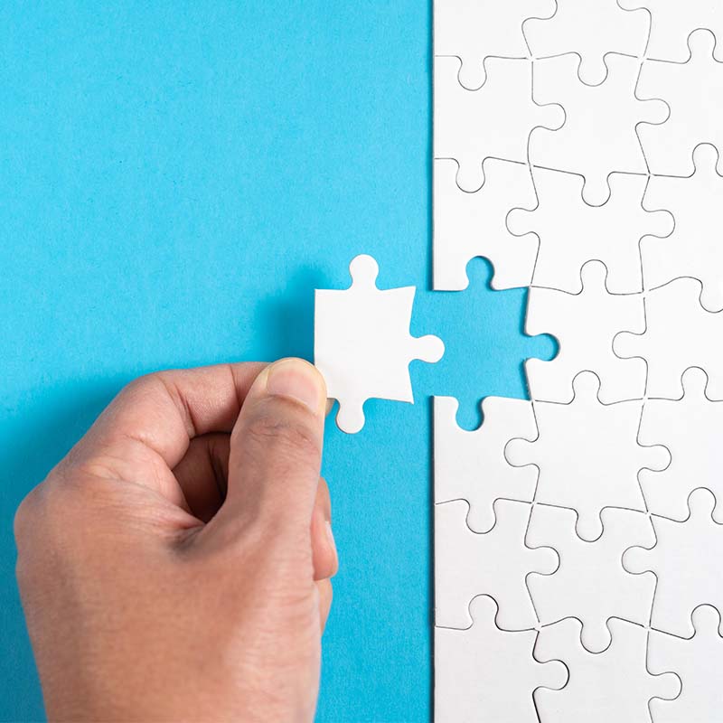 I human hand placing a puzzle metaphorically defining the problem in product development